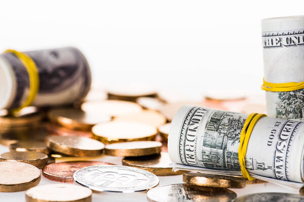 крупным планом банкнот и биткойнов, выделенных на белом
 