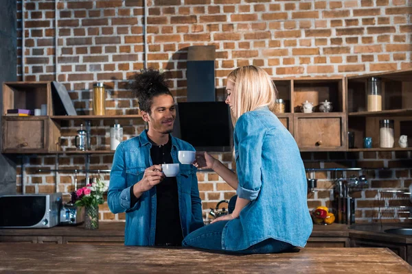 Jovem Casal Multirracial Com Xícaras Café Falando Cozinha Casa — Fotografia de Stock