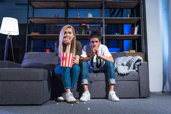 Känslomässiga Unga Multiracial Par Med Popcorn Titta Skräckfilm Soffan Tillsammans — Stockfoto