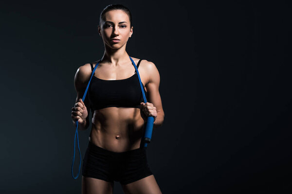 beautiful sportswoman with jump rope for cardio training, isolated on grey  