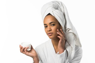 african american woman in bathrobe and towel applying face cream,  isolated on white clipart