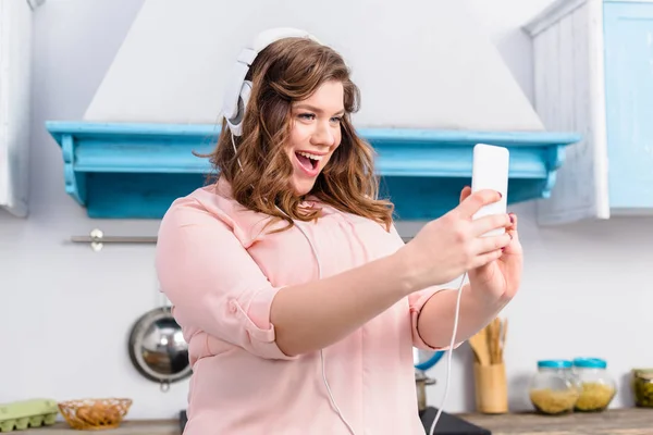 Mujer Con Sobrepeso Emocional Auriculares Tomando Selfie Teléfono Inteligente Cocina — Foto de stock gratis