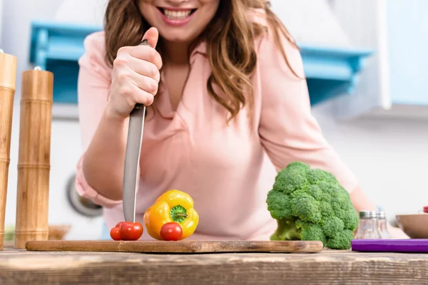 家庭厨房新鲜蔬菜餐桌上带刀的微笑妇女的部分看法 — 图库照片