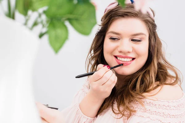 Retrato Jovem Sorridente Aplicando Brilho Labial Enquanto Faz Maquiagem Casa — Fotografia de Stock