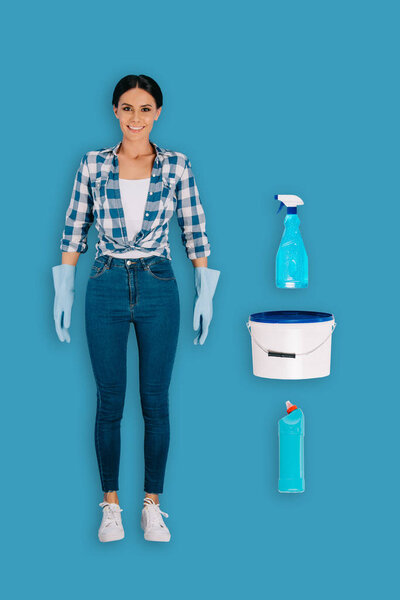 top view of female cleaner in protective gloves with bottle spray, bucket and cleaning fluid isolated on blue background