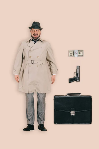 男性杀手的顶部视图与手枪 金钱和公文包在粉红色背景下隔离 — 图库照片