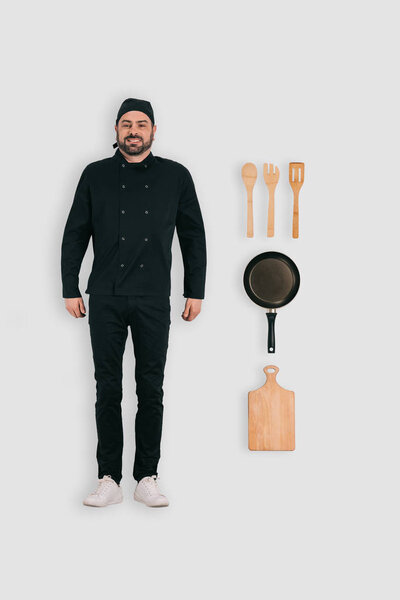 верхний вид мужского шеф-повара с сковородкой, разделочной доской и лопатками на белом фоне
