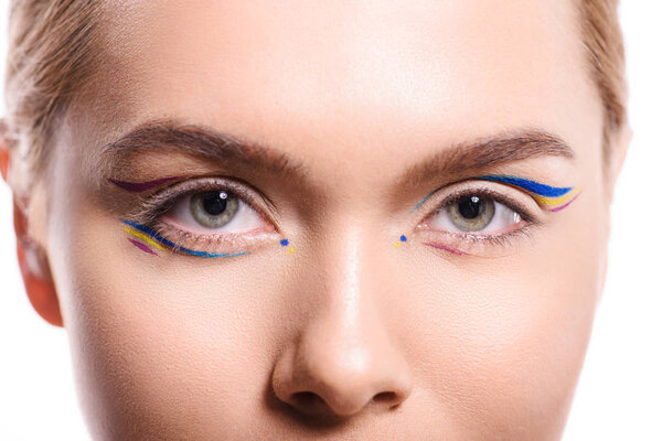 cropped image of woman with colored makeup with lines looking at camera isolated on white