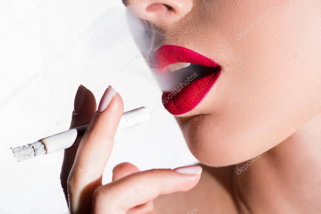 cropped image of woman smoking cigarette and exhaling smoke isolated on white