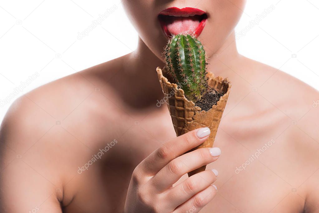cropped image of woman licking cactus potted in ice cream cone isolated on white