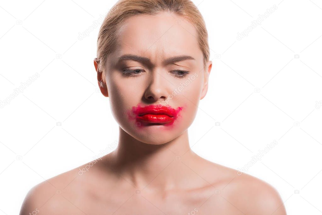 upset woman with smeared red lipstick on face looking down isolated on white