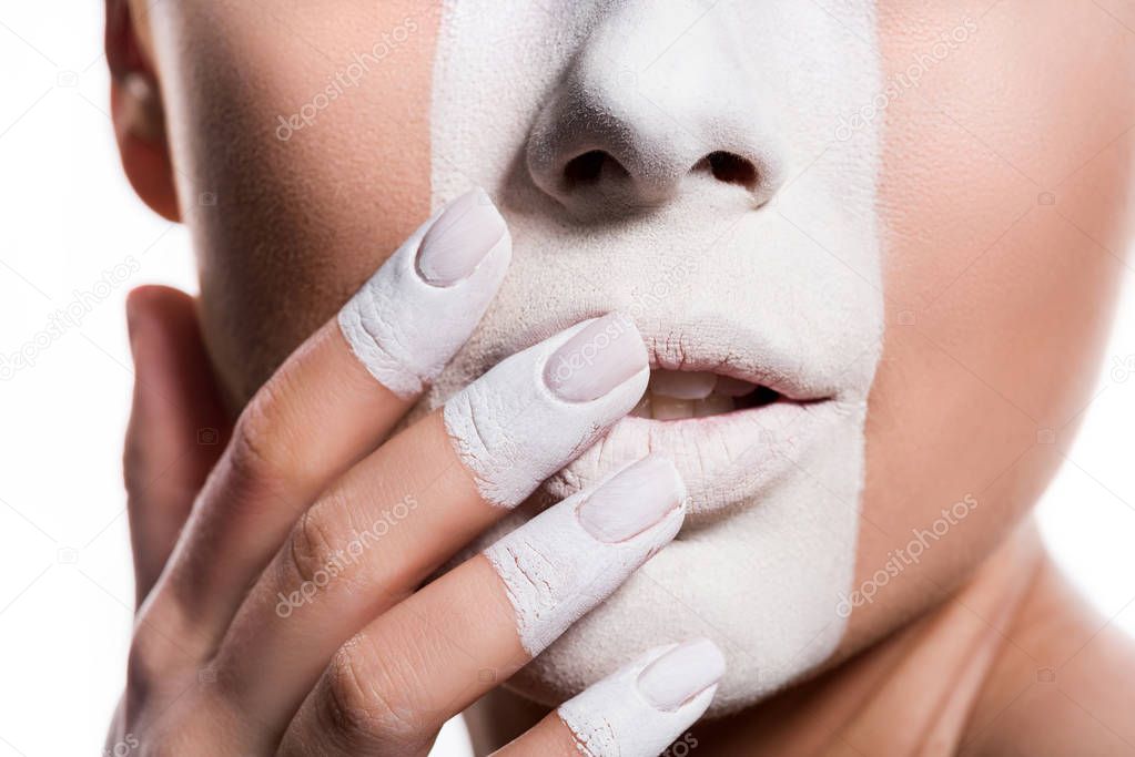 cropped image of woman with white paint on face and fingers touching lips isolated on white