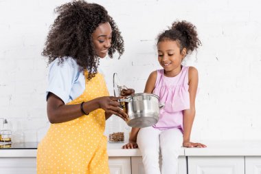 mutlu Afrika kökenli Amerikalı anne ve kızı birlikte mutfak pişirme