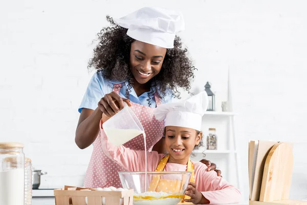 Madre Hija Afroamericana Sombreros Chef Vertiendo Leche Tazón Con Ingredientes — Foto de Stock