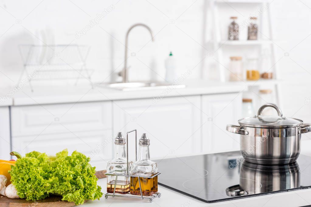 fresh ingredientes and electric stove with saucepan on kitchen