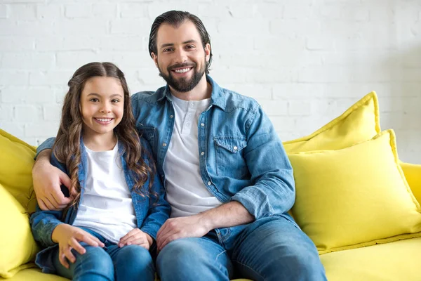 Feliz Padre Hija Sentados Juntos Sofá Amarillo Sonriendo Cámara —  Fotos de Stock