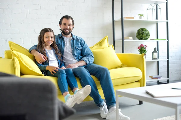 Happy Father Daughter Sitting Together Yellow Couch Smiling Camera — Free Stock Photo