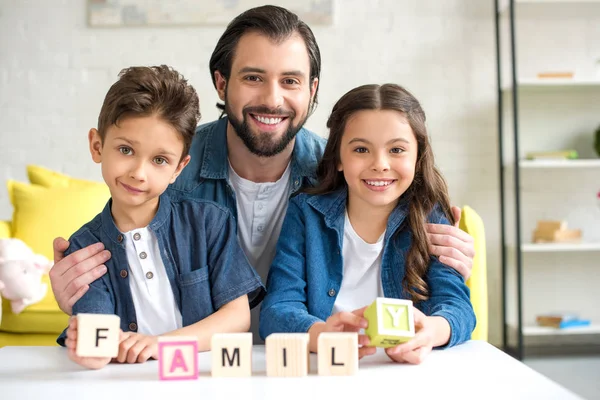 Feliz Padre Con Dos Hijos Sosteniendo Cubos Con Palabra Familia — Foto de Stock