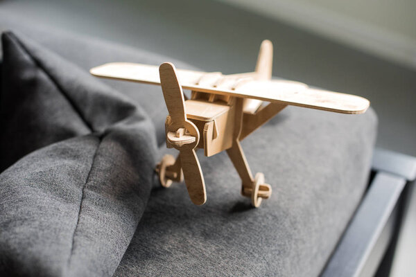 крупным планом модель деревянного игрушечного самолета на диване
