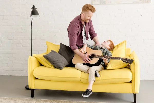 Happy Redhead Father Son Playing Acoustic Guitar Together Home — Stock Photo, Image