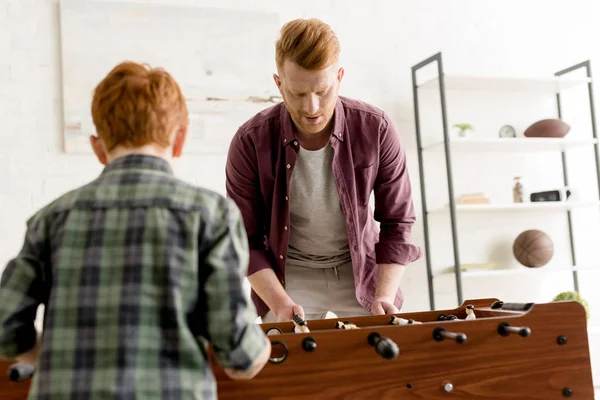 红头发的爸爸和儿子在家一起玩桌球 — 图库照片