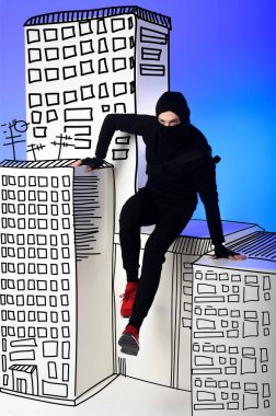 ninja in black clothing with katana behind getting across on drawing buildings on blue clipart