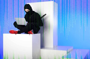 siyah giyim kodu mavi ile beyaz blokta otururken dizüstü kullanarak Ninja