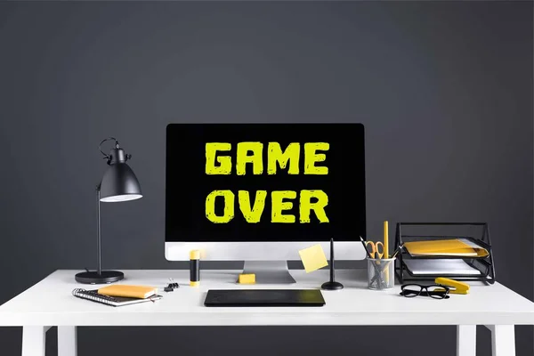 桌面电脑游戏超过题字在屏幕上 图形片剂和办公用品在工作场所 — 图库照片