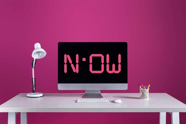 настольный компьютер с надписью на экране, клавиатура, компьютерная мышь и канцелярские принадлежности на столе
