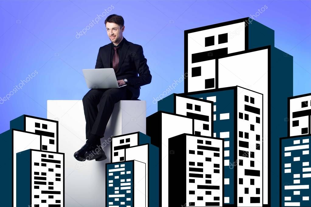 smiling businessman with laptop sitting on white block between drawing buildings on blue
