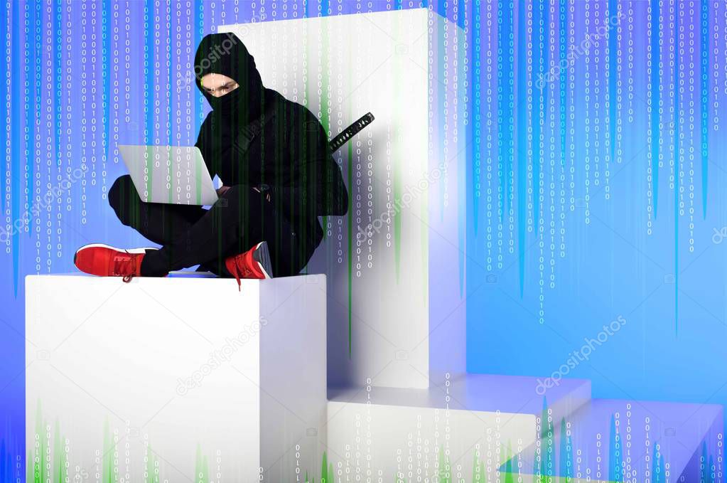 ninja in black clothing using laptop while sitting on white block with code on blue