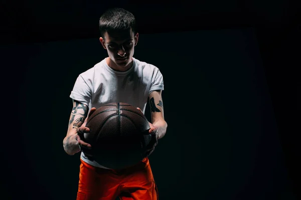 Hombre Uniforme Prisión Sosteniendo Pelota Baloncesto Sobre Fondo Oscuro — Foto de stock gratis