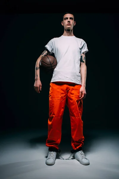 Young Male Prisoner Wearing Orange Pants Cuffs Holding Basketball Ball — Free Stock Photo