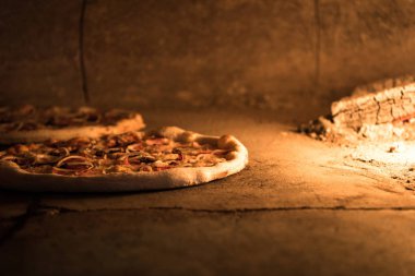 close up view of italian pizza baking in brick oven in restaurant clipart