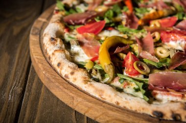 ahşap kesme tahtası üzerinde taze pişmiş İtalyan pizza görünümü kadar kapatın