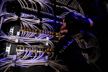 cropped shot of hackrers hands in gloves and various cables clipart