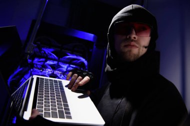 hacker'laptop uzakta kablolar ile arka plan üzerinde arıyor ile. gözlük yan görünüm