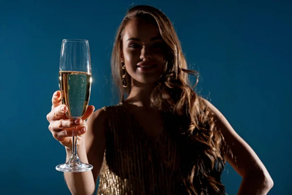 有吸引力的妇女显示香槟在晚上孤立的蓝色 — 图库照片