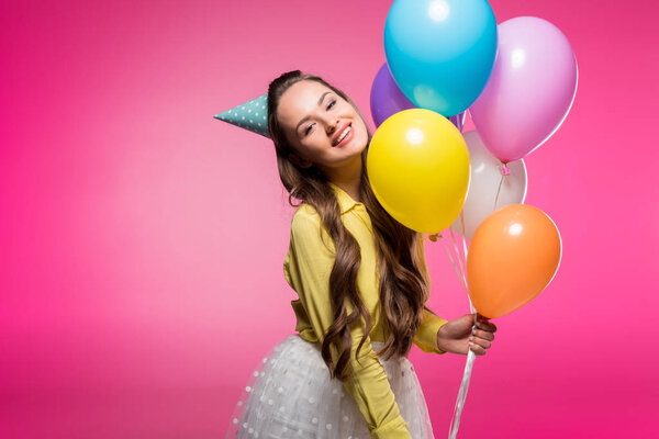 Atractiva mujer posando con sombrero de fiesta y globos aislados en rosa — Imagen de stock Atractiva Mujer Posando Con Sombrero Fiesta Globos Aislados Rosa Imágenes De Stock Sin Royalties Gratis