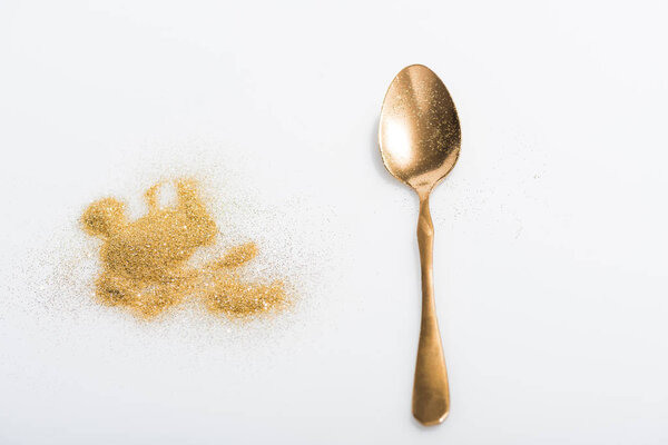 golden spoon and bright glitter isolated on white