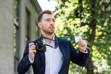 photojournalist in formal wear with digital photo camera and press pass  clipart