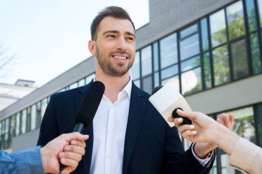 two journalists interviewing successful businessman with microphones clipart