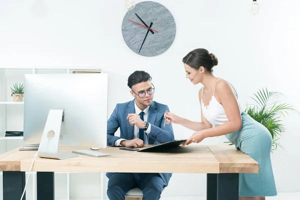 Bonita secretaria hablando con el jefe en la oficina - foto de stock