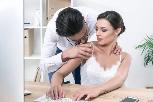 Geschäftsmann küsst Kollegin während der Arbeit — Stockfoto