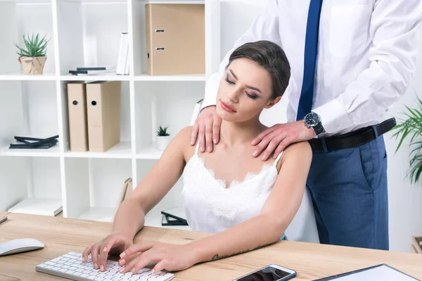 Mujer de negocios disfrutando de masaje de colega en el lugar de trabajo - foto de stock