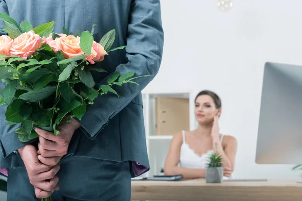 Businessman holding roses for colleague — Stock Photo