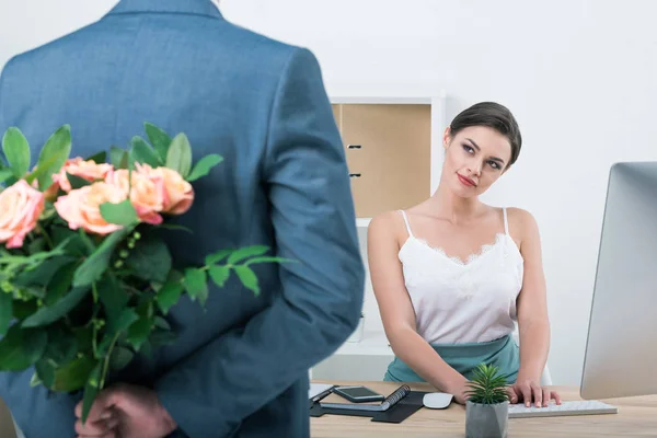 Businessman holding roses for colleague — Stock Photo