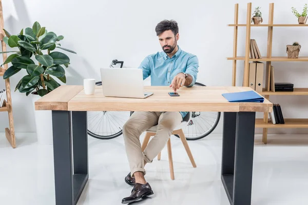 Homme d'affaires avec ordinateur portable sur le lieu de travail — Photo de stock