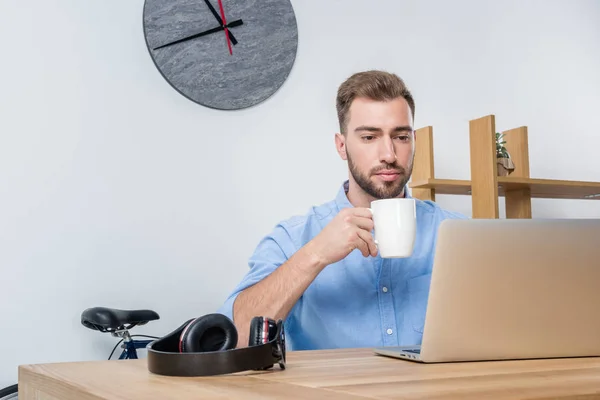 Hombre de negocios trabajando con el ordenador portátil en la oficina - foto de stock