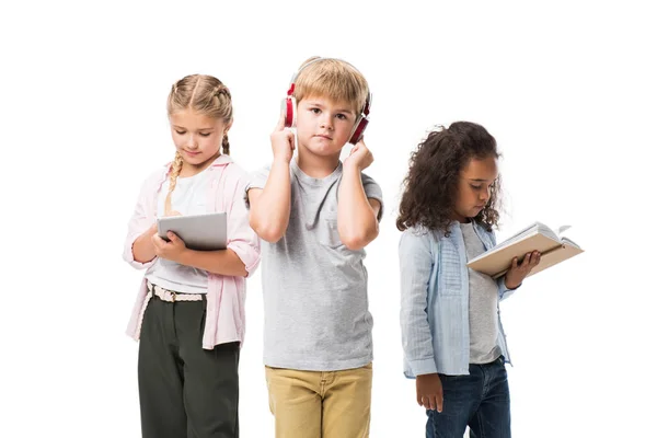 Niños con gadgets y libro - foto de stock